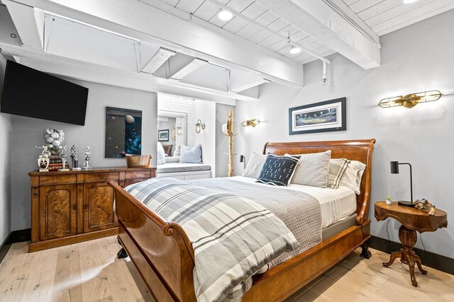 bedroom featuring light wood-type flooring and beam ceiling