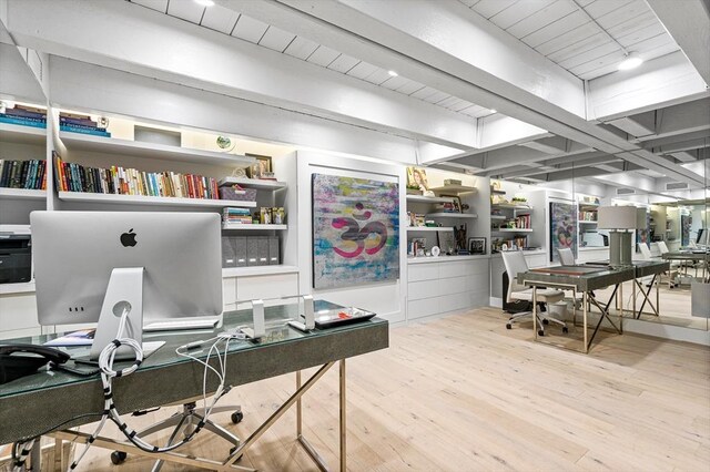 home office with light wood-type flooring and beam ceiling