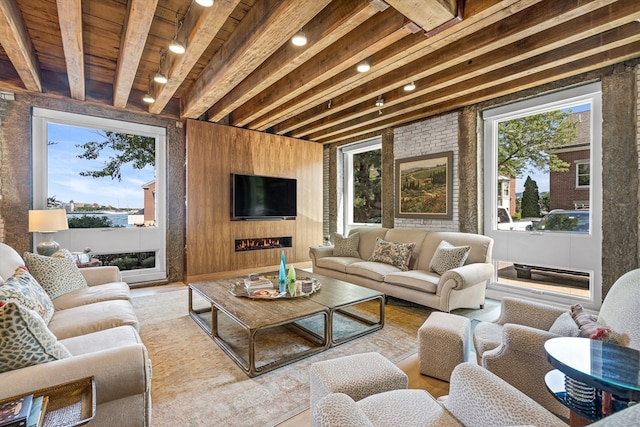 living room with wood walls, wood ceiling, and beam ceiling