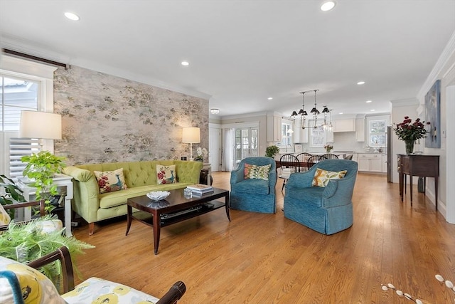 living area featuring ornamental molding, plenty of natural light, and light wood finished floors