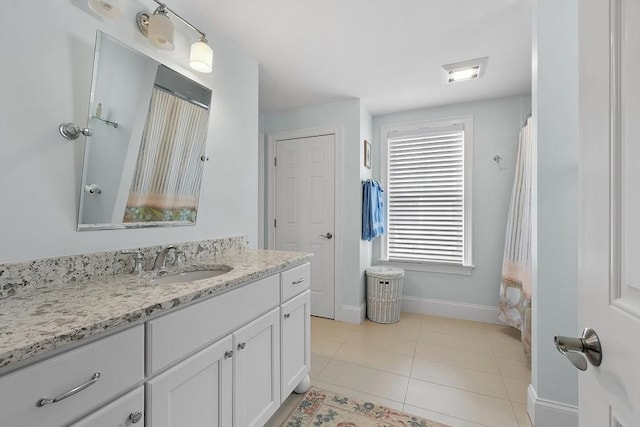 bathroom with vanity, baseboards, and tile patterned floors