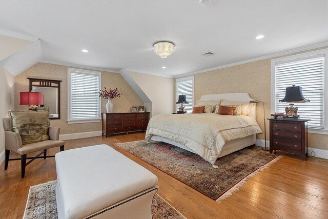 bedroom with ornamental molding and wood finished floors