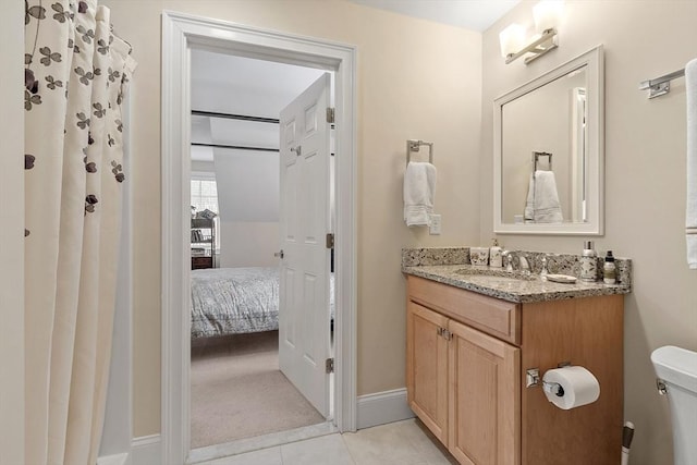 bathroom with tile patterned flooring, toilet, connected bathroom, vanity, and baseboards