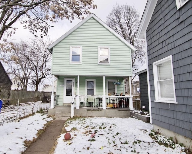 view of front of home featuring a porch and fence