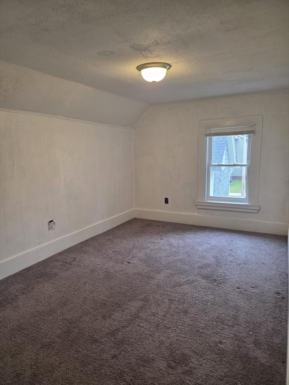 288 Quincy St, Springfield, MA 01109 - spare room featuring a textured ceiling, dark colored carpet, and vaulted ceiling