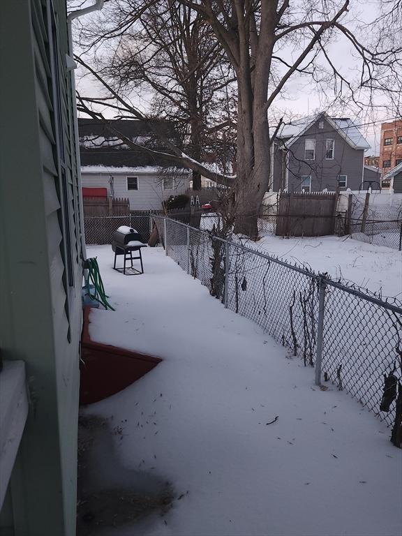 snowy yard featuring fence