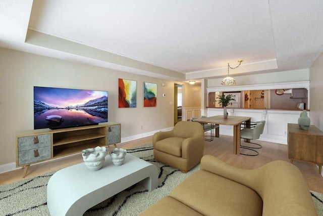 living room featuring a raised ceiling and wood-type flooring