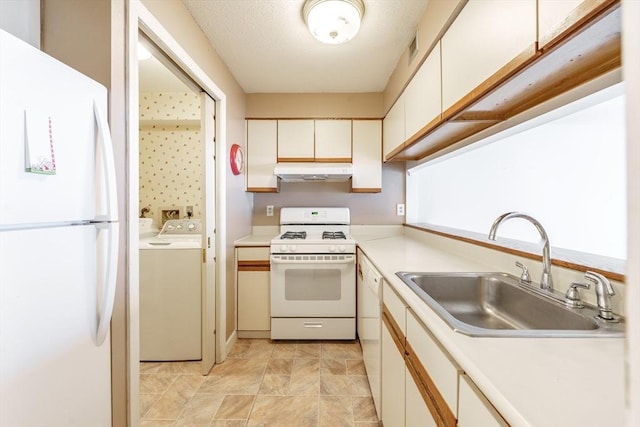 kitchen with white appliances, sink, white cabinets, and washer and clothes dryer