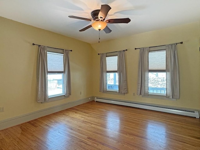 unfurnished room featuring baseboard heating, ceiling fan, and light wood-type flooring