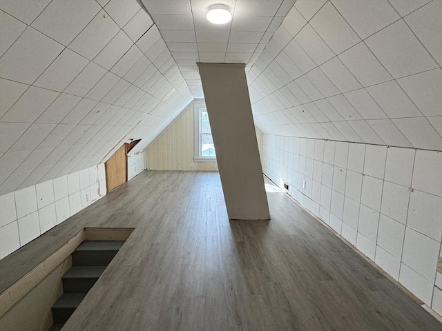 bonus room with lofted ceiling and hardwood / wood-style floors