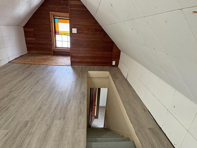 additional living space featuring wood-type flooring and vaulted ceiling