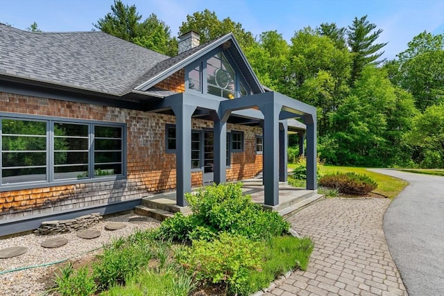 7 Penhollow Ln, Hampton Falls, NH 03844 - property entrance featuring a chimney and roof with shingles