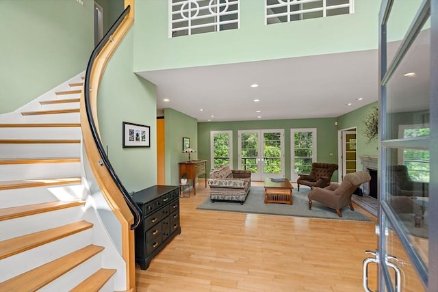 7 Penhollow Ln, Hampton Falls, NH 03844 - living area with light wood-type flooring, stairs, recessed lighting, french doors, and a fireplace