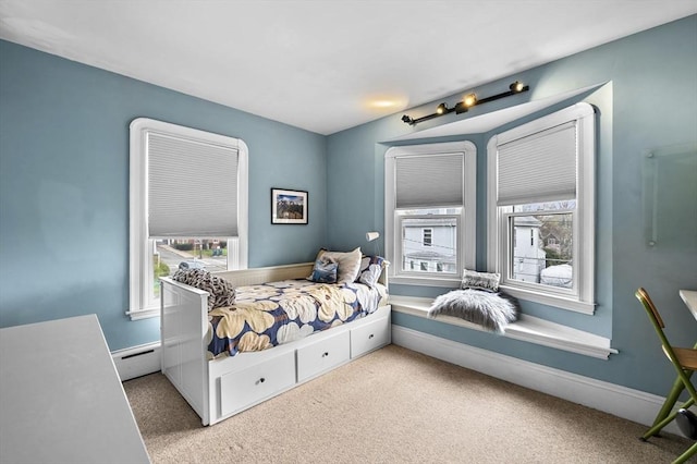 bedroom featuring multiple windows, light carpet, and baseboard heating