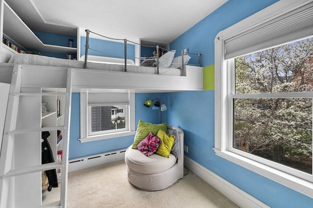 bedroom with carpet and a baseboard heating unit