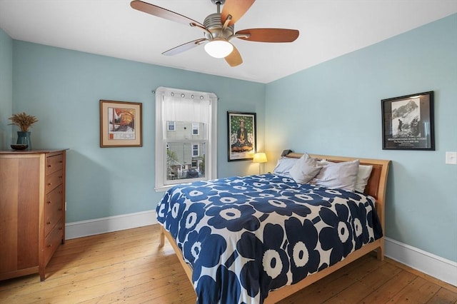 bedroom with ceiling fan, baseboards, and hardwood / wood-style floors