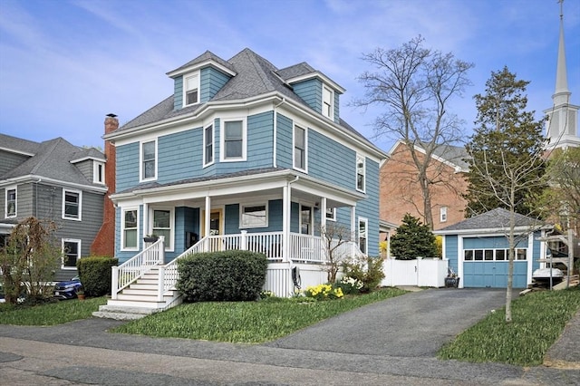 traditional style home featuring an outbuilding, fence, a garage, a porch, and aphalt driveway