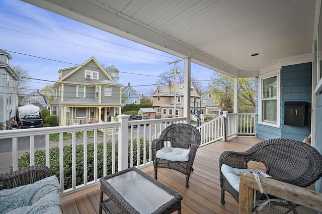 deck with covered porch and a residential view