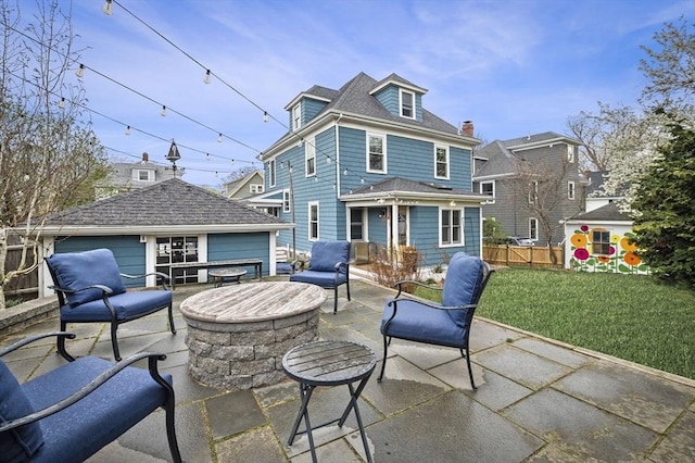 rear view of house featuring a yard, a patio area, fence, and an outbuilding