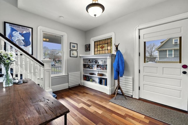 doorway to outside with stairway, baseboards, and wood finished floors