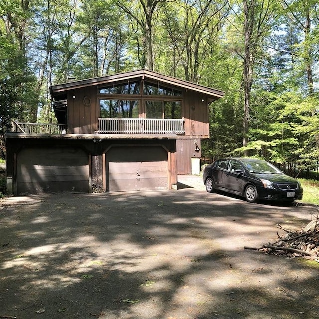 view of property exterior with asphalt driveway and an attached garage
