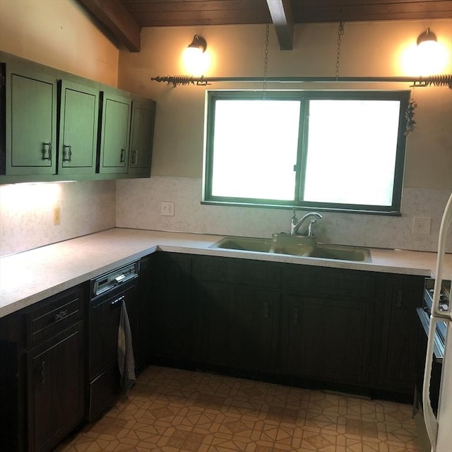 kitchen featuring green cabinetry, a sink, healthy amount of natural light, beamed ceiling, and decorative backsplash