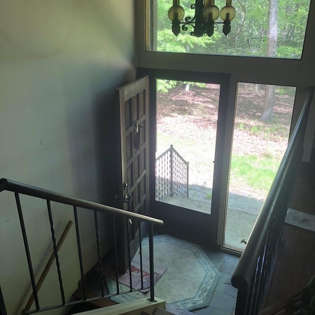 stairs featuring plenty of natural light and a chandelier