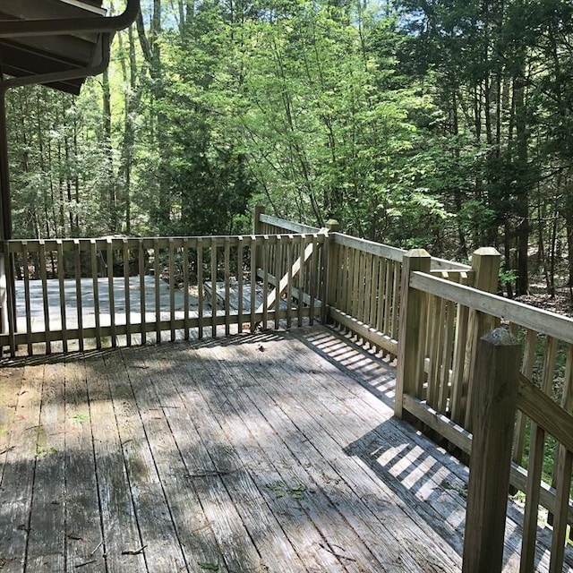 wooden terrace featuring a wooded view