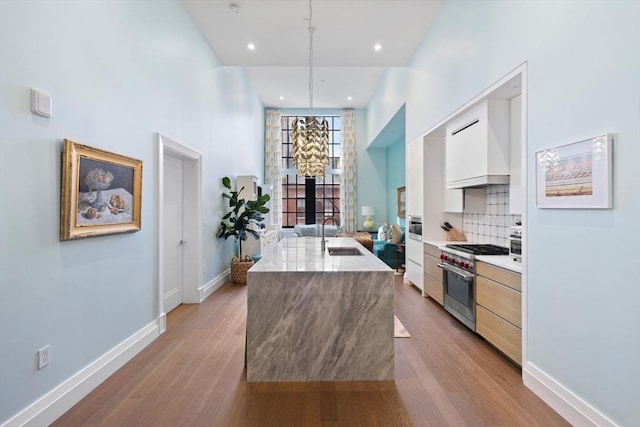 45 Temple St Unit 410, Boston, MA 02114 - kitchen featuring a kitchen island with sink, modern cabinets, a sink, light wood finished floors, and stainless steel appliances
