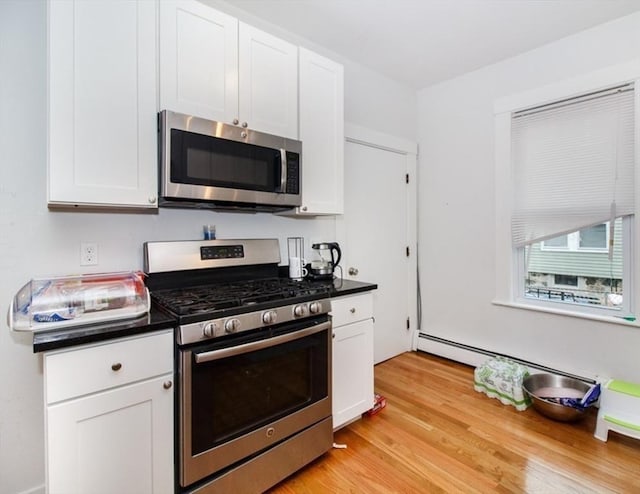 134 Brown St, Waltham, MA 02453 - kitchen with stainless steel appliances, dark countertops, and white cabinetry