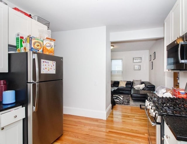 134 Brown St, Waltham, MA 02453 - kitchen featuring appliances with stainless steel finishes, light wood-style floors, white cabinets, baseboards, and open floor plan