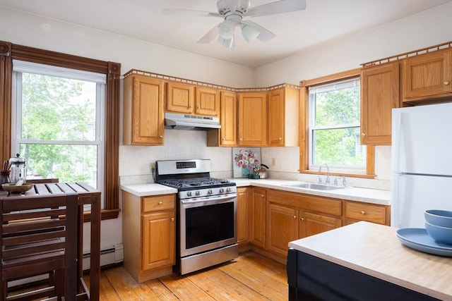 134 Brown St, Waltham, MA 02453 - kitchen featuring gas range, freestanding refrigerator, under cabinet range hood, a sink, and light countertops