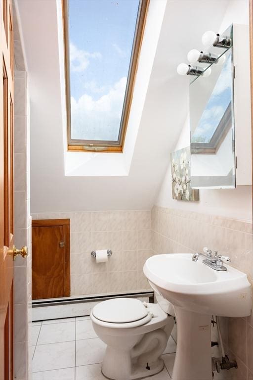 134 Brown St, Waltham, MA 02453 - bathroom featuring a skylight, tile walls, toilet, vaulted ceiling, and wainscoting