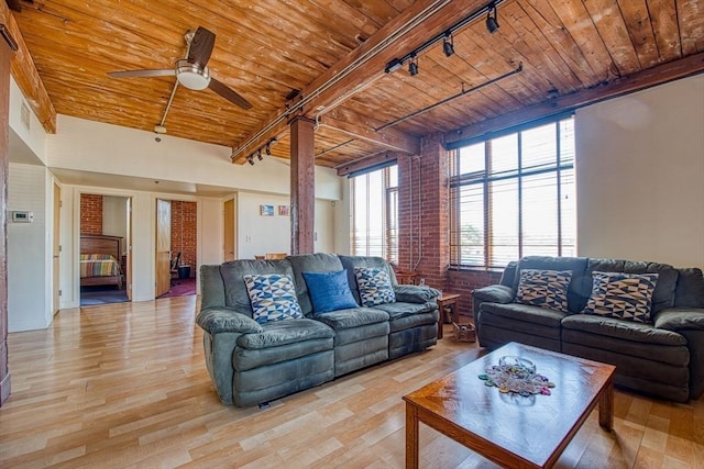 147 Centre St Unit 201, Brockton, MA 02302 - living room featuring wood ceiling with exposed beams, track lighting, ceiling fan, light wood finished floors, and brick wall