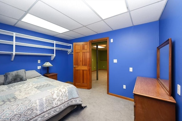 bedroom with light colored carpet and a drop ceiling