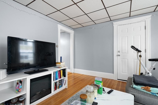 living room with a paneled ceiling and hardwood / wood-style floors