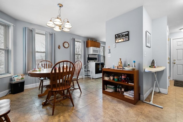 dining space with light tile patterned flooring and a notable chandelier