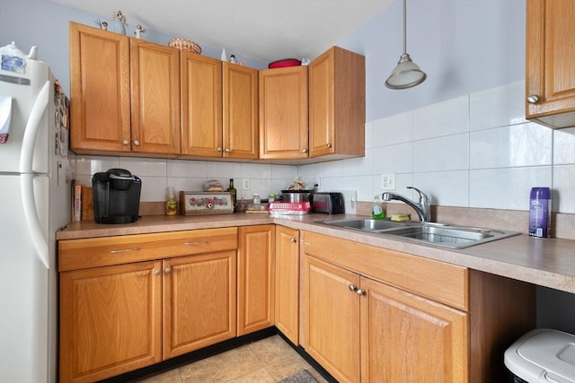 kitchen featuring pendant lighting, decorative backsplash, sink, light tile patterned floors, and white refrigerator