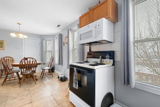 kitchen with white appliances, an inviting chandelier, backsplash, hanging light fixtures, and light tile patterned floors