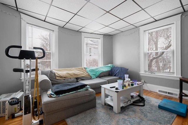 exercise room featuring a paneled ceiling and hardwood / wood-style floors