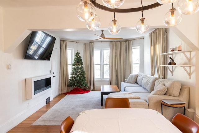 living room with hardwood / wood-style floors, ceiling fan, and ornamental molding