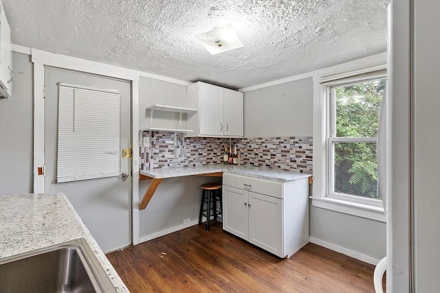 205-207 High St, Fitchburg, MA 01420 - kitchen featuring dark wood-style flooring, open shelves, decorative backsplash, white cabinetry, and a textured ceiling