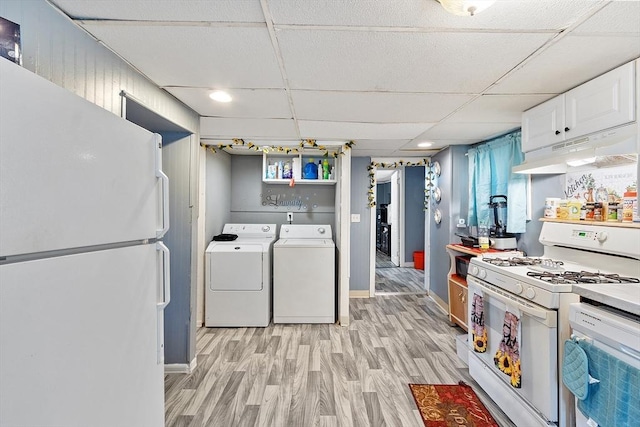 205-207 High St, Fitchburg, MA 01420 - kitchen featuring white appliances, under cabinet range hood, washer and clothes dryer, white cabinets, and light wood finished floors