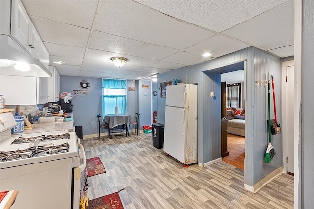 205-207 High St, Fitchburg, MA 01420 - kitchen featuring white appliances, light wood-type flooring, white cabinetry, light countertops, and a paneled ceiling