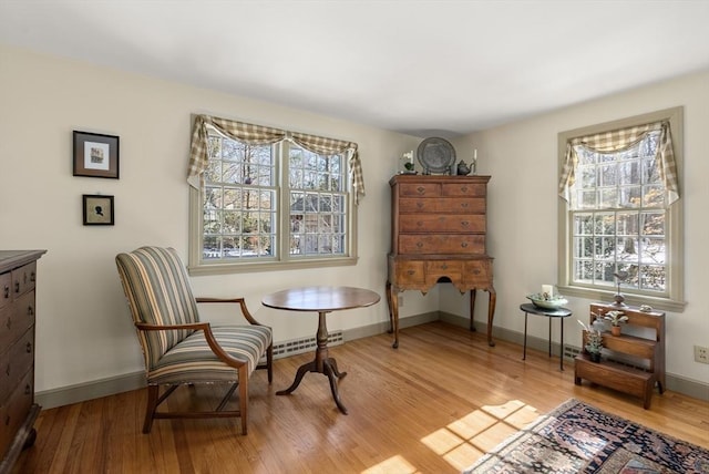 living area with baseboards, plenty of natural light, visible vents, and light wood finished floors