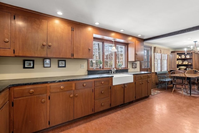 kitchen featuring plenty of natural light, brown cabinets, and a sink