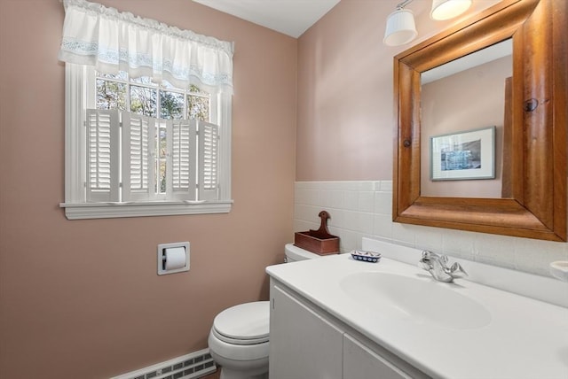 bathroom featuring toilet, a baseboard radiator, vanity, and tile walls