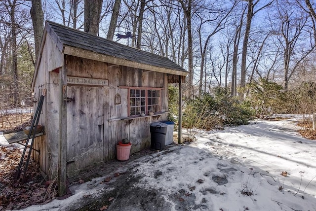 snow covered structure with an outbuilding