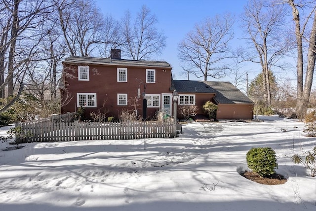 view of front of home featuring a fenced front yard and a chimney