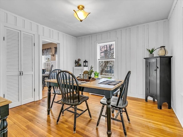 dining area with a decorative wall and light wood-style floors